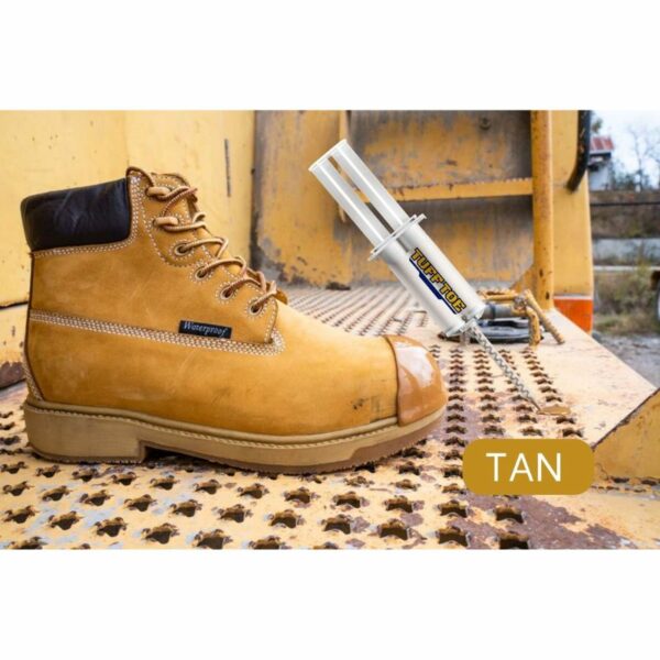 Tan waterproof work boot on a rusted metal surface with a tube of 'TUFF TOE' product placed next to it, indicating toe protection or reinforcement.