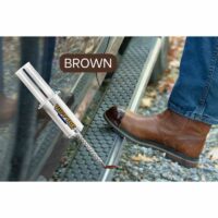 Person wearing a brown leather boot with tuff toe applied stepping on a metal grate, with a TUFF TOE adhesive tube prominently displayed nearby, emphasizing the color 'BROWN'.